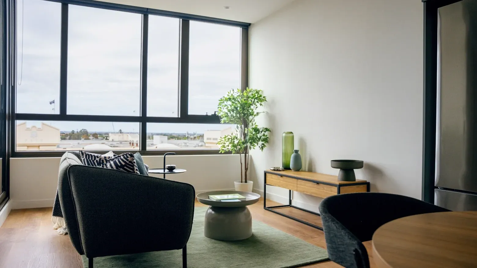 Living room with modern furniture and large windows at Caulfield Place.