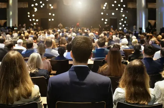 Attendees seated at professional conference listening to keynote speaker