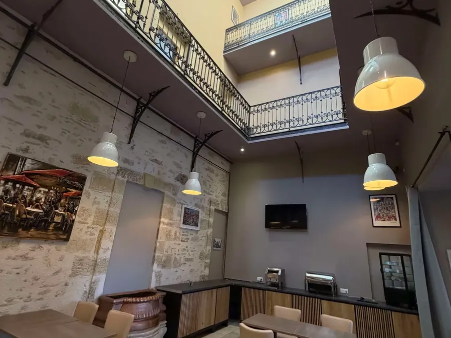 Salle à manger élégante avec balcon et télévision au Grand Hôtel Molière.