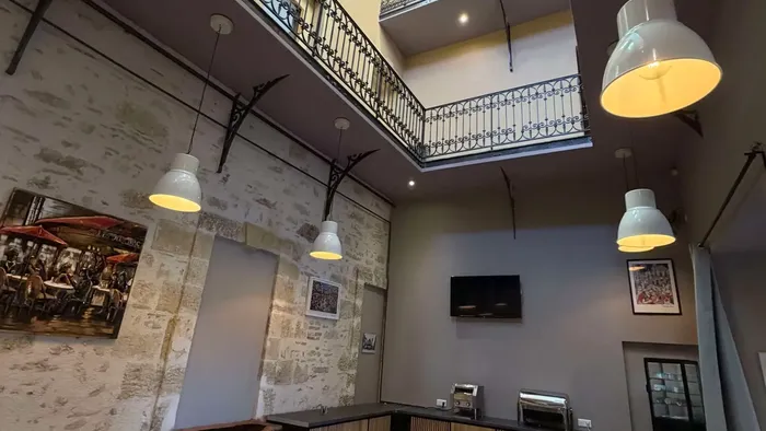 Salle à manger élégante avec balcon et télévision au Grand Hôtel Molière.