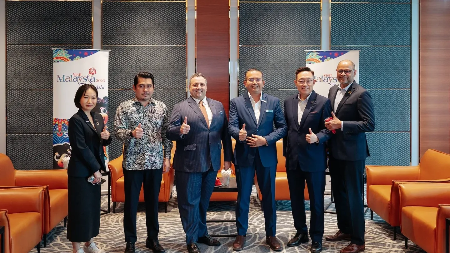 Sunway's management team pose thumbs up with Tourism Malaysia team in a modern meeting space.