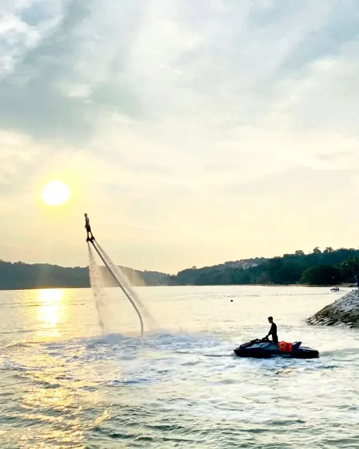 A person performing flyboarding over the sea at sunset – Lexis Hibiscus Port Dickson