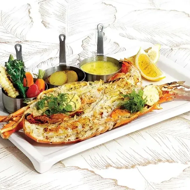 A beautifully presented lobster on a white plate - Lexis Hotel Group