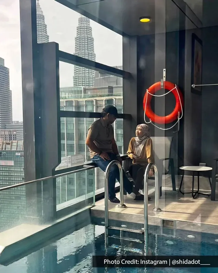 Couple relaxing at a private pool with the KLCC skyline in the background.