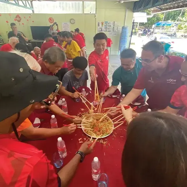 A group of people tossing yee sang together during Chinese New Year - Lexis Suites Penang