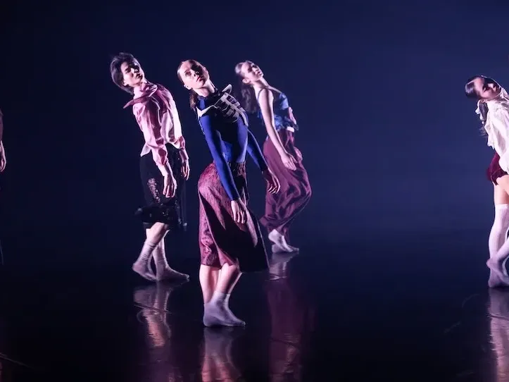 Group of dancers performing a dance routine on a stage at an event.