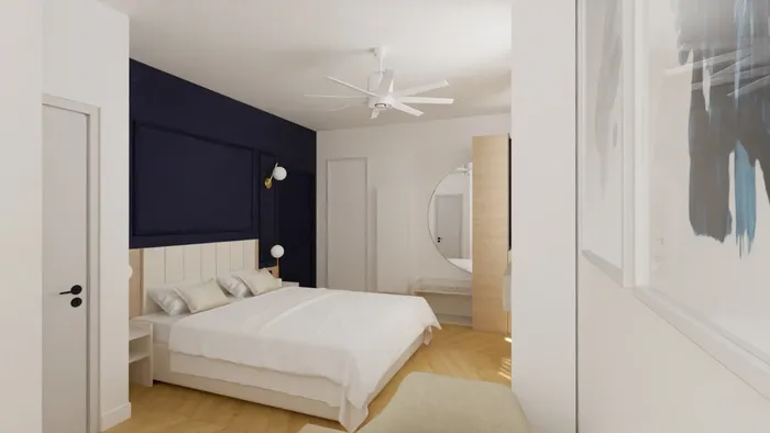 Chambre élégante avec lit double, mur bleu, ventilateur, et décoration moderne chez Les Sources Callou.