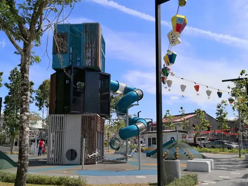 A playground featuring a colorful slide and a large climbing structure for children to play on - Lexis Suites Penang