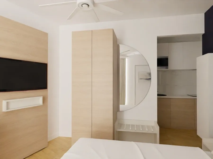 Chambre moderne avec lit, télévision, placard et cuisine intégrée chez Les Sources Callou.