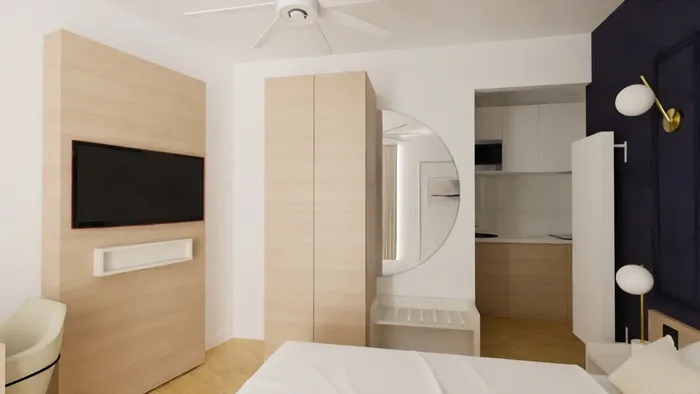 Chambre moderne avec lit, télévision, placard et cuisine intégrée chez Les Sources Callou.