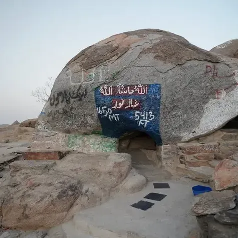 Exterior of the historic Cave of Jabal Thawr on a rocky mountain with painted inscriptions near Saja by Warwick Makkah