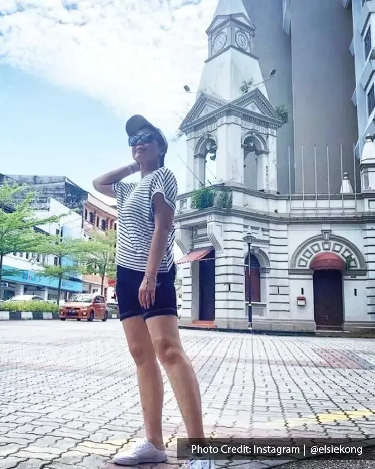 A lady was striking a pose and taking a picture with the Taiping Colonial Tower - Lexis Suites Penang