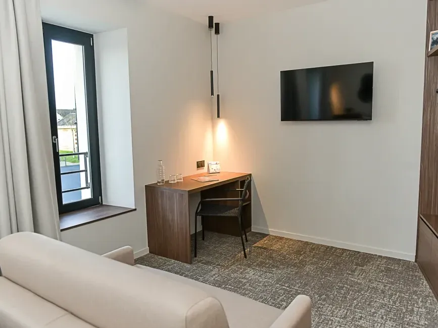 Chambre Comfort moderne avec bureau, télévision et vue sur la ville à Hôtel Rivella, Clisson.