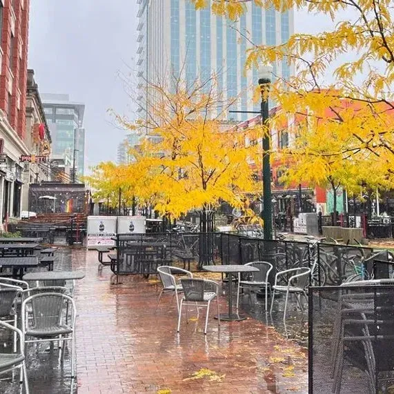 Wet urban patio with empty chairs and autumn trees in downtown Boise near Hotel 43