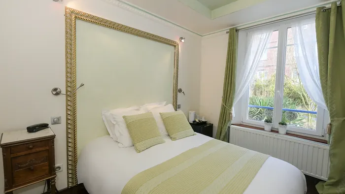 Chambre élégante avec lit, cadre doré, et fenêtre à l'Hôtel Villa Aultia