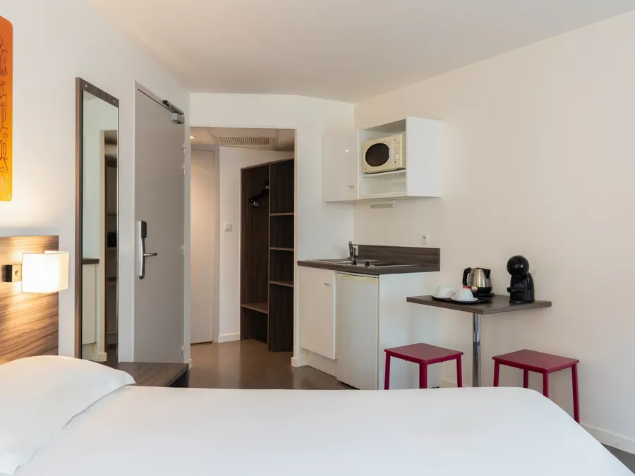Quadruple studio with kitchenette and comfortable beds at Appart’Hôtel Hévéa in Valence.